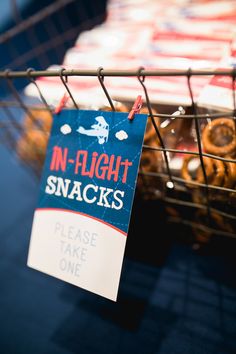 a sign that is attached to a wire basket filled with doughnuts and pretzels