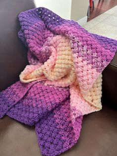 a crocheted blanket sitting on top of a couch