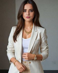 a woman wearing a white blazer and tan pants