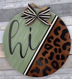 a wooden sign with the word chi on it and a cheetah print bow