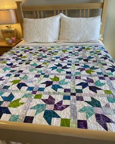 a bed with white pillows and quilted bedspread