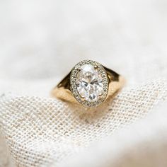 a diamond ring sitting on top of a white cloth