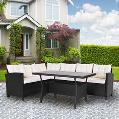 a patio furniture set sitting on top of a stone floor in front of a house