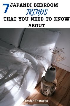 a bed sitting on top of a wooden floor next to a white comforter and pillows