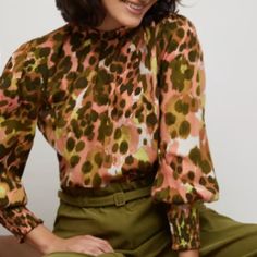 An Eye-Catching Abstract Pink Leopard Print Blouse That Has A Powerful Silhouette Along With Mock-Neck And Smocked Cuffs. Finish This Look With Olive Straight Legged Pants Or Dark-Wash Jeans. Mock Neck, 3/4 Length Sleeves, Smocked Cuffs, Unique Leopard Print. 100% Polyester. Machine Washable. Imported Bust: 36"- 37.5" Waist: 29"- 30" Length: 27" Pink High Neck Tops For Fall, Pink High Neck Top For Fall, Pink Stretch Tops For Work, Stretch Pink Tops For Workwear, High Neck Tops For Workwear In Spring, Feminine Multicolor Blouse For Work, Feminine Green Tops For Workwear, Pink Spring Blouse For Work, Spring Pink Blouse For Work