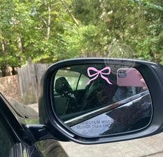 a rear view mirror with a pink bow on it