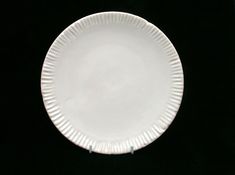 a white plate sitting on top of a black table