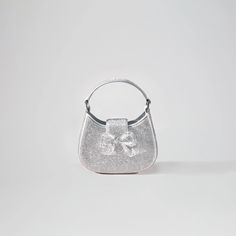 Lustrous in silver, the sleek futuristic curves of the Crescent Bag comes completely bedazzled in rhinestones. Micro yet maximalist in the best way possible, this small but mighty bag is a sight for sore eyes. A silver diamanté bow adds the finishing touch, and is ideal for styling with your favourite looks for invite- Crescent Bag, Sore Eyes, Small But Mighty, Bow Bag, Purple Rhinestone, Leather Bows, Purple Bags, Black Rhinestone