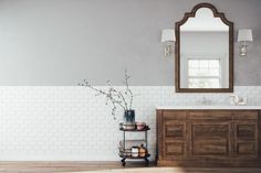 a bathroom with a sink, mirror and wooden cabinet in the middle of the room