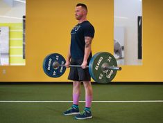 a man holding a barbell in a gym