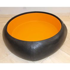 a large black and orange bowl sitting on top of a tiled floor