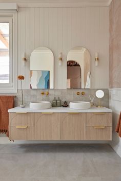 a bathroom with two sinks and mirrors on the wall