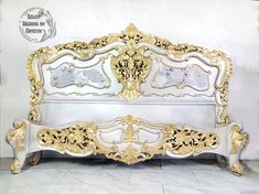 an ornate white and gold bed frame in a room with tile flooring on the walls