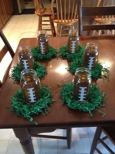 a wooden table topped with lots of glass jars filled with footballs