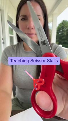 a woman holding up a pair of scissors with the words teaching scissor skills on it