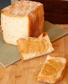 a loaf of bread sitting on top of a cutting board next to two slices of bread