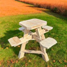 a wooden picnic table sitting in the grass