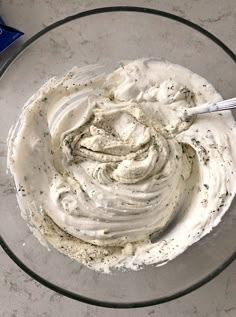 a glass bowl filled with whipped cream on top of a table