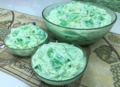 three glass bowls filled with green food on top of a table next to another bowl