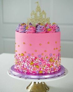 a pink and purple cake with a gold crown on top