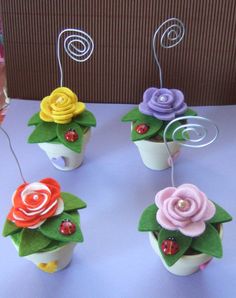 four cupcakes with flowers and ladybugs on them are sitting on a table