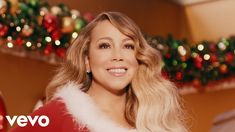 a woman with long blonde hair wearing a red and white christmas outfit, smiling at the camera