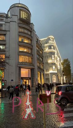 people are walking around in front of a building with the eiffel tower on it