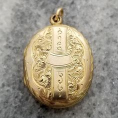 This is a lovely finely detailed antique oval shaped locket. The front and back are decorated in intricate etched designs. It opens up to reveal a compartment perfect for two photos. The locket measures 1 1/8 inch (29.33mm) tall, including loop 11/16 inch (19.22mm) wide It is unmarked but appears to be yellow gold filled. It weighs 3.5 grams It is in good wearable condition, it does show some signs of wear from being a piece of vintage estate jewelry. All it needs is a chain to hang from (chain in photos not included). Please inspect photos closely before purchasing. This item will be shipped fully insured in the US. Just send me a message if you have any questions. Elegant Engraved Locket Necklace With Oval Link, Heirloom Style Oval Pendant Locket Necklace With Vintage Charm, Heirloom Oval Engraved Locket Necklace, Elegant Oval Pendant Locket Necklace From Vintage Collection, Collectible Heirloom Hallmarked Locket Necklace, Elegant Oval Pendant Locket Necklace For Vintage Collection, Formal Locket Necklace With Intricate Round Pendant, Antique Hallmarked Locket Necklace For Anniversary, Victorian Engraved Oval Cabochon Jewelry