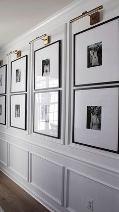 a white wall with black and white pictures hanging on it's sides, along with wooden flooring