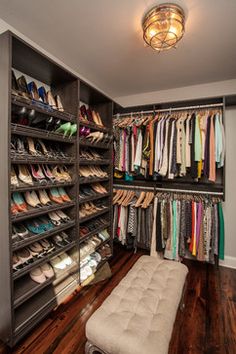 an organized closet with lots of shoes and footwear on the shelves, along with a bench