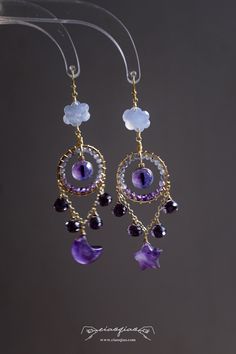 ---- Welcome to CiaoQiao Shop ----- "Regal Amethyst Dreamcatcher Earrings," a pair that weaves together the mystical allure of amethyst with the delicate beauty of star and moon. These earrings feature intricate dreamcatcher-inspired hoops adorned with sparkling faceted amethyst beads that catch the light with every movement. The centerpiece of each earring is a cat eye. Dangling gracefully below are faceted amethyst gems, including whimsical star moon shapes, which add to the majestic vibe of t Handmade Celestial Purple Jewelry, Handmade Purple Celestial Jewelry, Purple Handmade Celestial Jewelry, Purple Celestial Dangle Earrings, Celestial Purple Dangle Earrings, Handmade Purple Celestial Earrings, Handmade Celestial Earrings For Festivals, Handmade Celestial Dangle Hoop Earrings, Nickel Free Purple Earrings For Festival