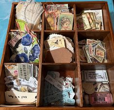 an open wooden box filled with lots of different types of paper and tags on it