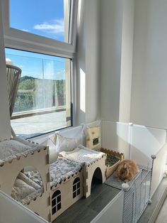 a dog laying on top of a bed next to a cat in a house shaped like a castle