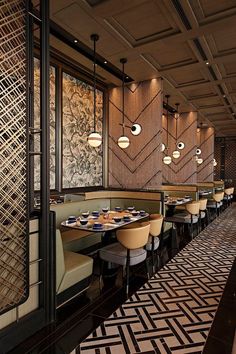 the interior of a restaurant with many tables and chairs, along with lights hanging from the ceiling