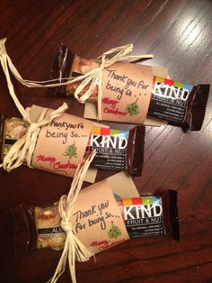 three candy bars wrapped in brown paper on top of a wooden table