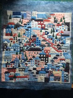 a quilted wall hanging on the side of a building