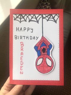 someone is holding up a birthday card with a spiderman on it and the words happy birthday