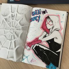 an open notebook with spider - man drawn on it, next to a drawing book