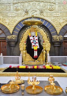 the statue is surrounded by gold plates and candles