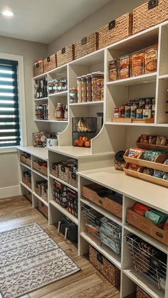 an organized pantry with white shelving and lots of food items in baskets on the shelves