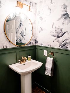 a white sink sitting under a bathroom mirror next to a wall mounted faucet