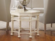 a white table sitting on top of a hard wood floor next to a couch and chair