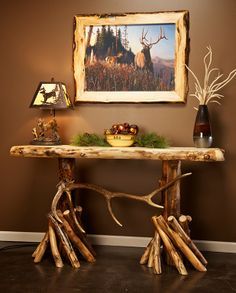 a wooden table with antlers on it in front of a painting and other decorations