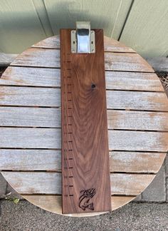 a wooden ruler sitting on top of a wooden table next to a wall and floor