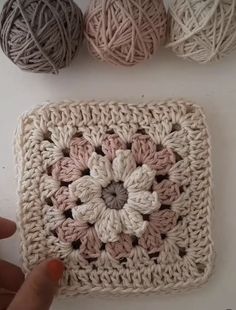 three balls of yarn sitting next to each other on a white surface with one ball of yarn in the middle