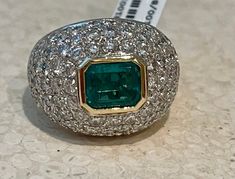 This 18 K white and yellow Gold emerald and diamond dome shaped cocktail ring features a nice bezel set emerald of approximately 2 carats wich is embedded by 100 pavé set diamonds of ca. 3 ct. The ring is currently size 55/15 but can be resized larger or smaller if necessary. Jewelry Knowledge, Emerald And Diamond Ring, Emerald Diamond Ring, Domed Ring, Baguette Diamond, 2 Carat, Emerald Diamond, Round Brilliant Cut Diamond, Cocktail Ring