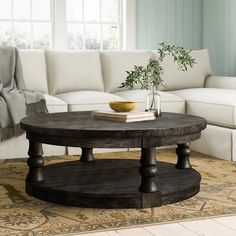 a living room with white couches and a wooden coffee table in the center area