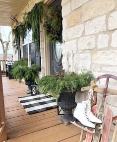 a pair of ice skates sitting on top of a wooden porch next to a planter