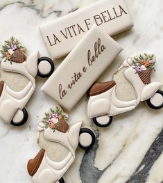 three cookies shaped like motor scooters with flowers on them and the words la vita e bella written in italian