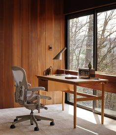 an office chair sitting in front of a desk with a lamp on top of it